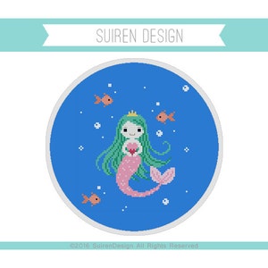 May include: A cross-stitch pattern featuring a mermaid with green hair and a pink tail holding a pink heart. The mermaid is surrounded by blue water with white bubbles and orange fish.