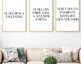 Puede incluir: Tres impresiones enmarcadas con texto en español en una pared blanca. El texto en las impresiones dice: "El que busca encuentra", "El que con lobos anda, a aullarse enseña", y "Más vale un pájaro en mano, que cien volando".