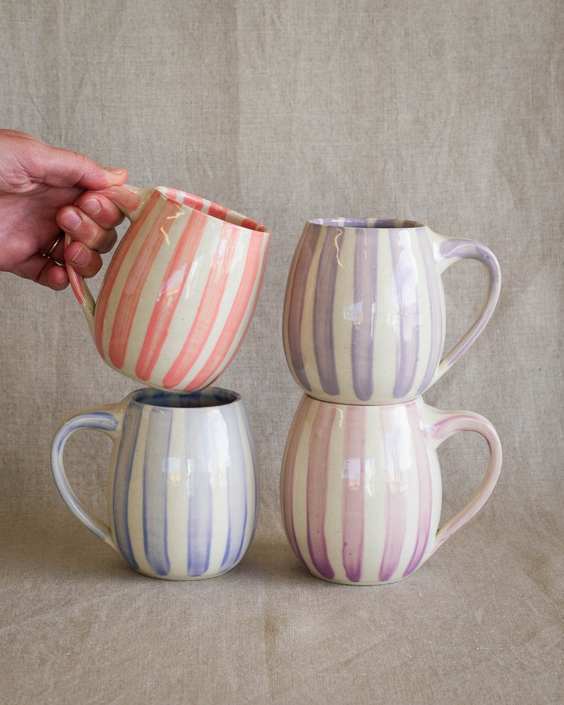 Handmade striped ceramic mugs in pink, lavender, periwinkle, and purple.