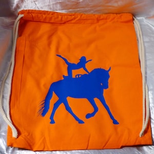 Op de afbeelding: Oranje trekkoordtas met een blauw silhouet van een persoon die een voltigeoefening op een paard uitvoert.