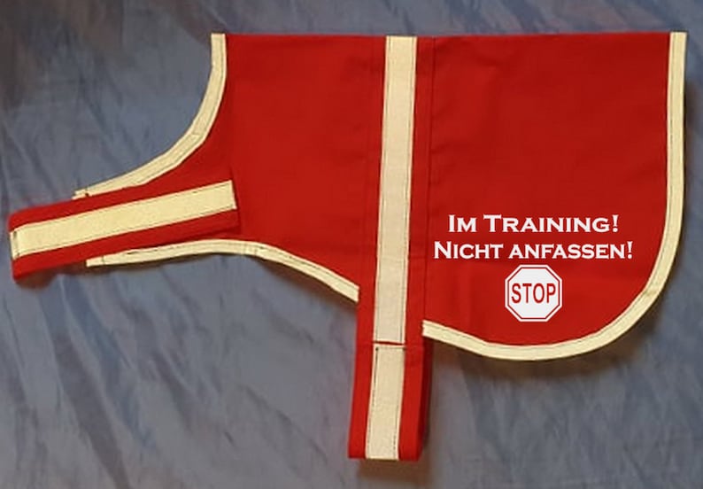 May include: Red dog training vest with white reflective trim and the text "IM TRAINING! NICHT ANFASSEN!" and a white "STOP" sign.