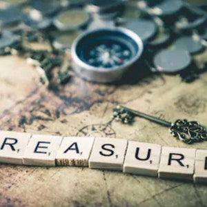 May include: A vintage treasure map with a compass, a key, and the word "TREASURE" spelled out in wooden letter tiles.