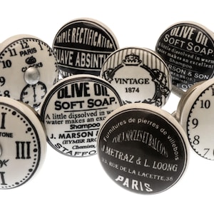 Peut inclure: Ensemble de 8 boutons de cabinet en céramique noir et blanc avec différents motifs. Les motifs comprennent un cadran d'horloge, une étiquette vintage et une étiquette pour du savon doux à l'huile d'olive. Les boutons mesurent environ 5 cm de diamètre.