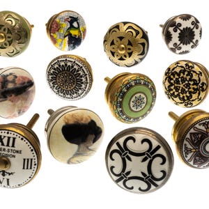 Peut inclure: Une collection de boutons de meubles décoratifs avec divers motifs. Les boutons présentent des garnitures en laiton et des faces en céramique avec des motifs floraux, géométriques et de portraits. Certains boutons ont un design de cadran d'horloge. La palette de couleurs comprend l'or, le blanc, le noir, le vert et le rose.