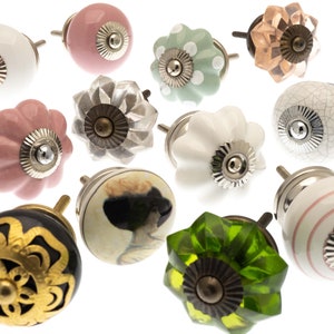 Op de afbeelding: Assortiment van 12 keramische en glazen kastknoppen in verschillende kleuren en patronen, waaronder roze, groen, wit en zwart. De knoppen hebben een vintage stijl en zijn perfect om elke woning een vleugje charme te geven.