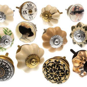 Peut inclure: Une collection de boutons de meubles décoratifs aux motifs variés. Les boutons présentent des motifs floraux, géométriques et de portraits, avec des couleurs crème, or, noir et marron. Certains boutons ont un design de cadran d'horloge.