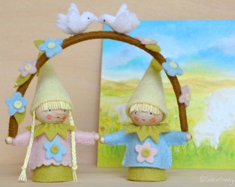 Two little gnomes holding an arch with doves handmade out of wool felt and wool. Waldorf inspired for on the nature table.