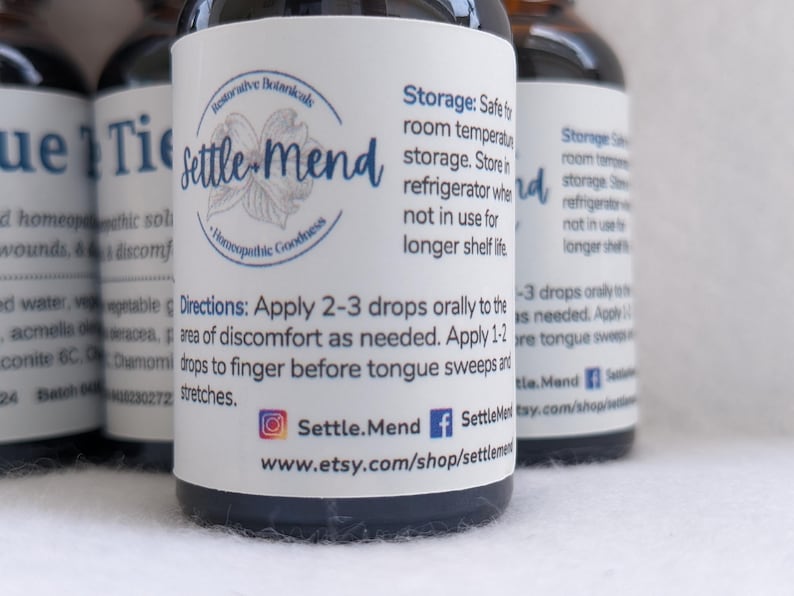 May include: Close-up of several small, dark glass bottles with white labels. The labels feature the text "Settle Mend" and detailed instructions. The bottles are for homeopathic remedies, with a focus on natural ingredients.