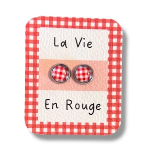 Peut inclure: Une paire de boucles d'oreilles à imprimé vichy rouge et blanc sur une carte avec le texte "La Vie En Rouge".