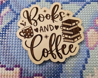 May include: A wooden sign with the text "Books and Coffee" in a decorative font. The sign features a stylized image of a coffee cup with polka dots and a stack of books.