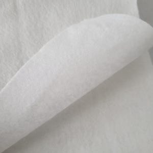 May include: Close-up of a white, fluffy fabric with a soft, textured appearance. The material is folded over, revealing a layered effect. The fabric appears to be lightweight and possibly used for crafting or sewing projects.