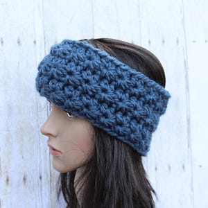 May include: A blue crocheted headband for women. The headband is made with a textured stitch and is wide enough to cover the ears.