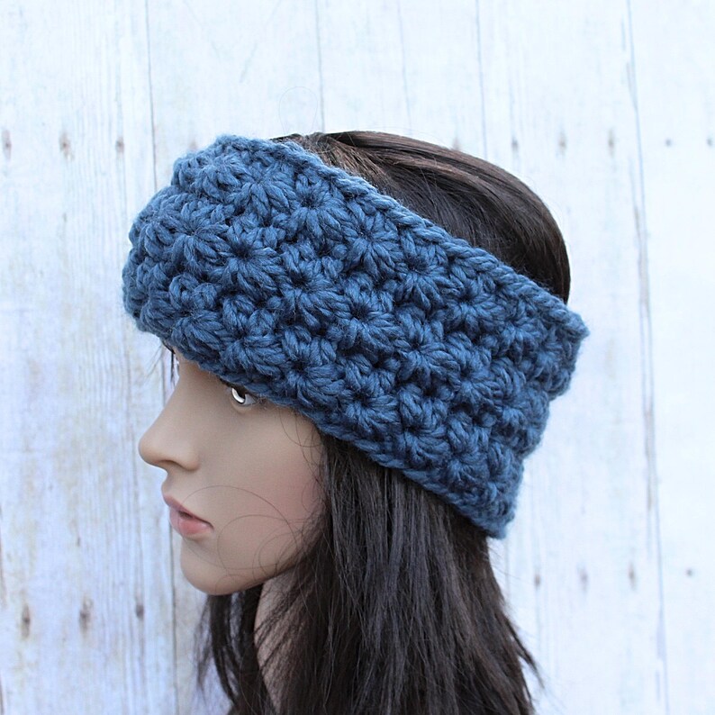 May include: A blue crocheted headband for women. The headband is made with a textured stitch and is wide enough to cover the ears.