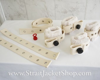 May include: Set of five white canvas restraints with black buckles and eyelets. Two long straps with eyelets are included.  www.StraitJacketShop.com