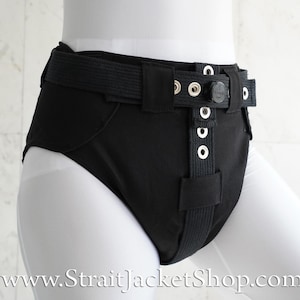 May include: Black undergarment with a black adjustable belt and silver buckles. The undergarment has a thick, padded waistband.