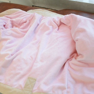 May include: A beige jacket with a pink fleece lining. The jacket is unzipped and turned inside out, showing the soft fleece lining.