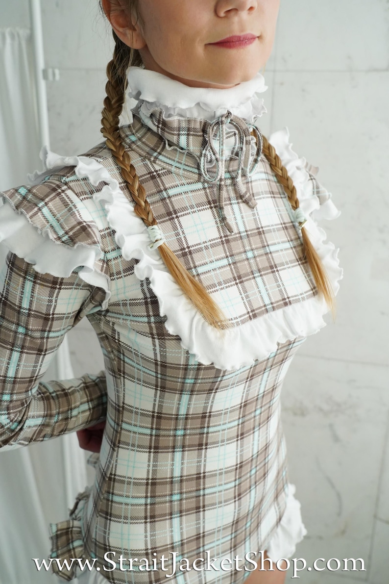 May include: A plaid dress with a high ruffled collar and long sleeves. The dress features a brown, white, and light blue plaid pattern. The website address www.StraitJacketShop.com is visible at the bottom of the image.