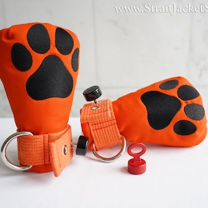 May include: A pair of orange fabric gloves with black paw prints. Each glove has a silver ring and a black buckle. A red magnetic clasp is also included.