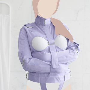 May include: A lavender-coloured, long-sleeved, padded straitjacket with adjustable straps and buckles. The jacket has a high collar and is designed to restrict movement of the arms.