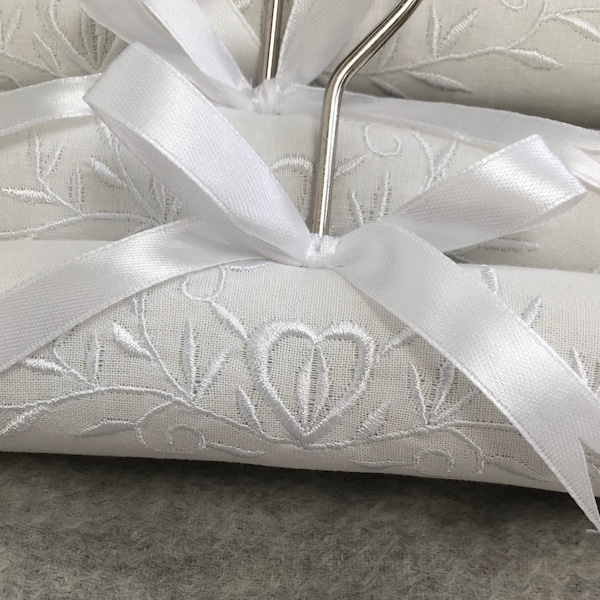 Cintres de luxe en coton blanc rembourré avec un beau coeur et une guirlande brodée