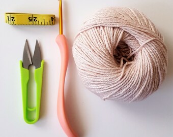 Crochet yarn, scissors and a ball of yarn on a bed · Free Stock Photo