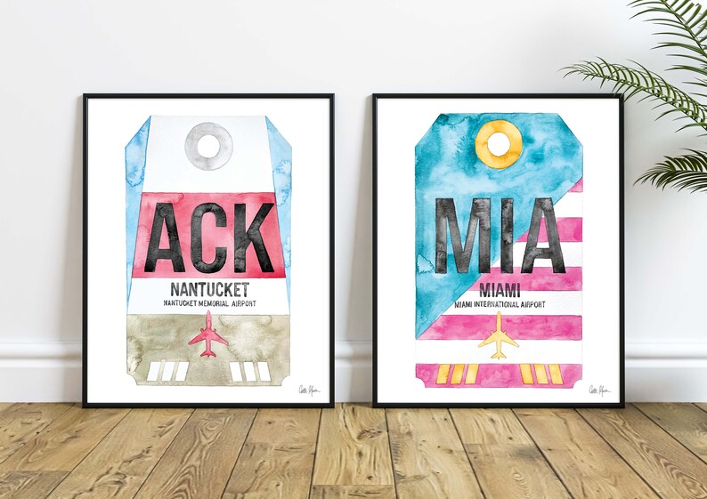 May include: Two watercolor prints of luggage tags with airport codes. The left print features a blue, red, and brown luggage tag with the code "ACK" and the text "NANTUCKET, NANTUCKET MEMORIAL AIRPORT". The right print features a blue, pink, and yellow luggage tag with the code "MIA" and the text "MIAMI, MIAMI INTERNATIONAL AIRPORT".