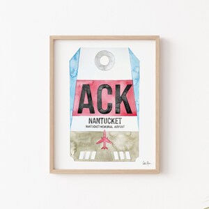 May include: A watercolor painting of a luggage tag with the airport code "ACK" and the text "NANTUCKET, NANTUCKET MEMORIAL AIRPORT". The tag is red, white, and blue with a small airplane in the bottom center.