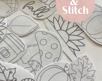 May include: A set of 10 iron-on patches featuring various fall-themed designs, including pumpkins, leaves, acorns, a coffee cup, a mushroom, and a sunflower. The patches are white with black outlines and the text "Hello Fall" is included. The patches are labeled "Stick & Stitch".