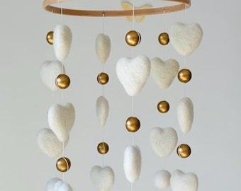 Felt heart baby mobile decorated with gold colored wooden beads