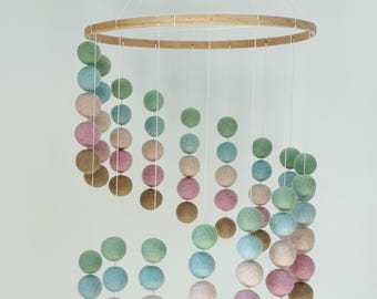 Vilten bal spiraal mobiel voor babykamer of speelkamerdecoratie in pastelkleuren.