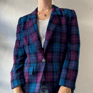 Könnte beinhalten: Ein blauer und lila karierter Blazer mit einem Knopfverschluss.