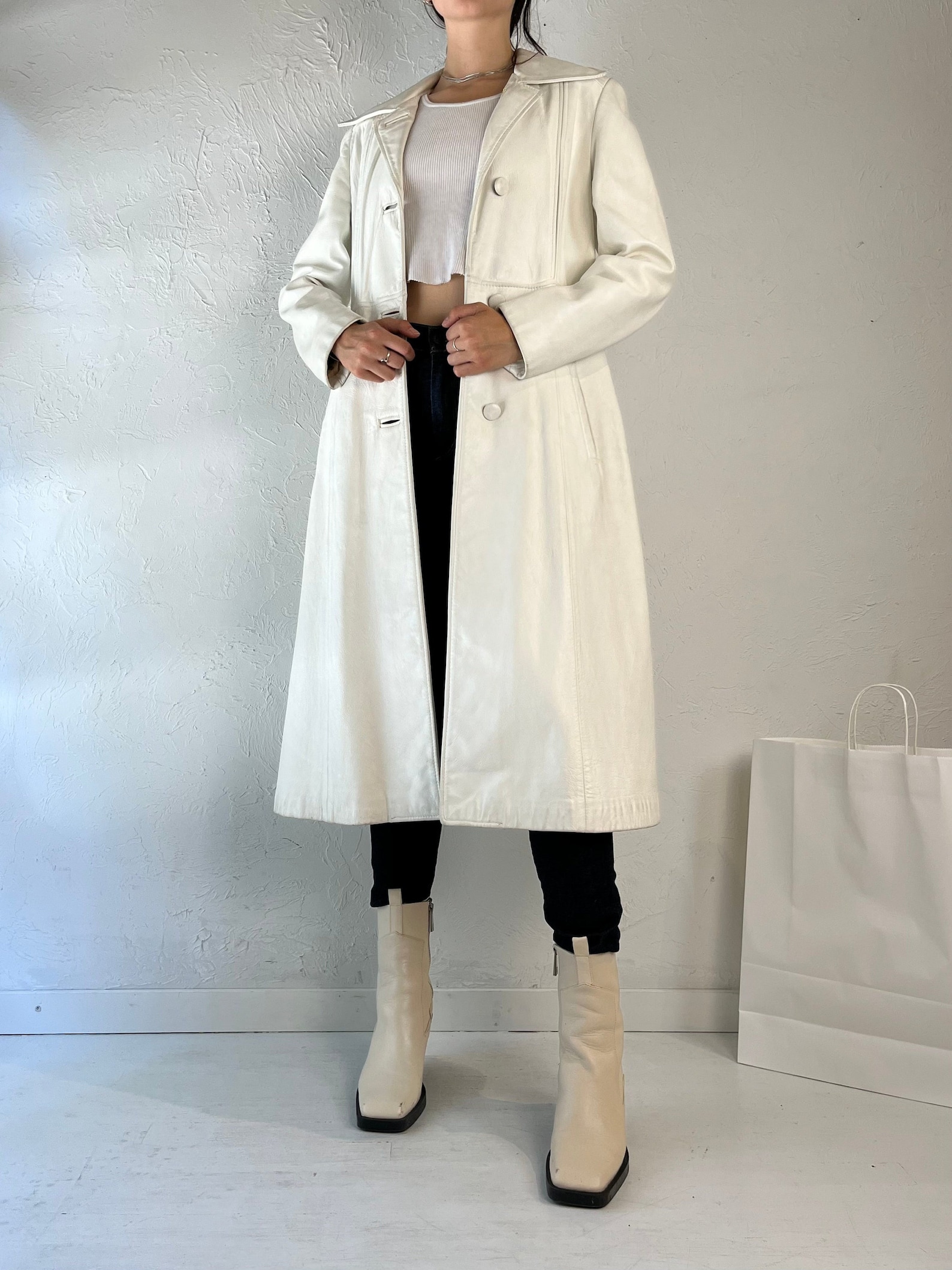 Vintage cream leather trench coat with single-breasted button fastening and side slit pockets.