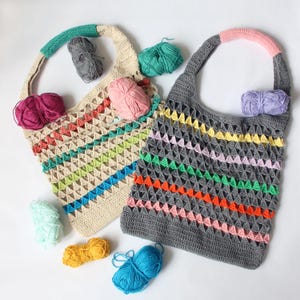 May include: Two crocheted bags with colourful stripes and a variety of yarn balls in different colours.