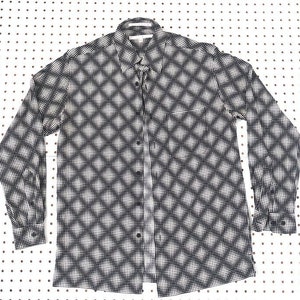 Puede incluir: Una camisa de manga larga con botones y un diseño geométrico en blanco y negro.