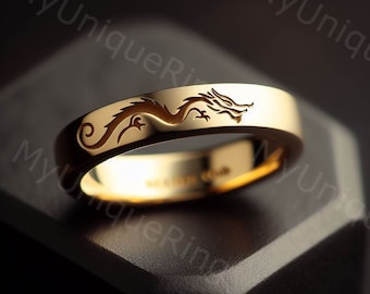 Könnte beinhalten: Ein goldener Ehering mit einem eingravierten Drachenmuster auf der Außenseite des Rings.