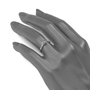 May include: A silver ring with a round, clear gemstone surrounded by smaller clear gemstones.