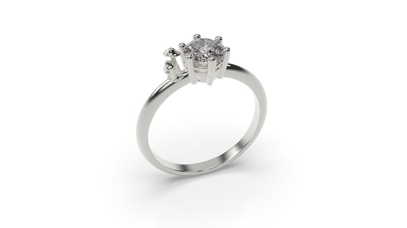 May include: A silver ring with a clear round gemstone and three small mushroom-shaped accents.