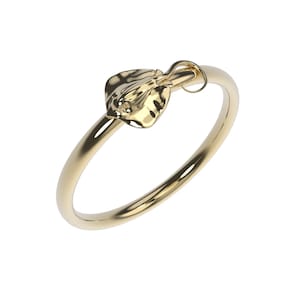 May include: A gold ring with a detailed, textured stingray design. The stingray is attached to the ring with a small loop.