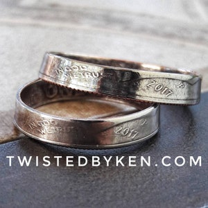 May include: Two silver rings made from US quarter coins. The rings are engraved with "In God We Trust" and the year "2017".