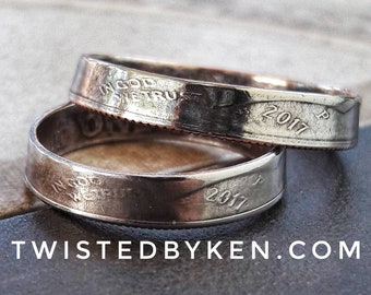 May include: Two silver rings made from US quarter coins. The rings are engraved with "In God We Trust" and the year "2017".
