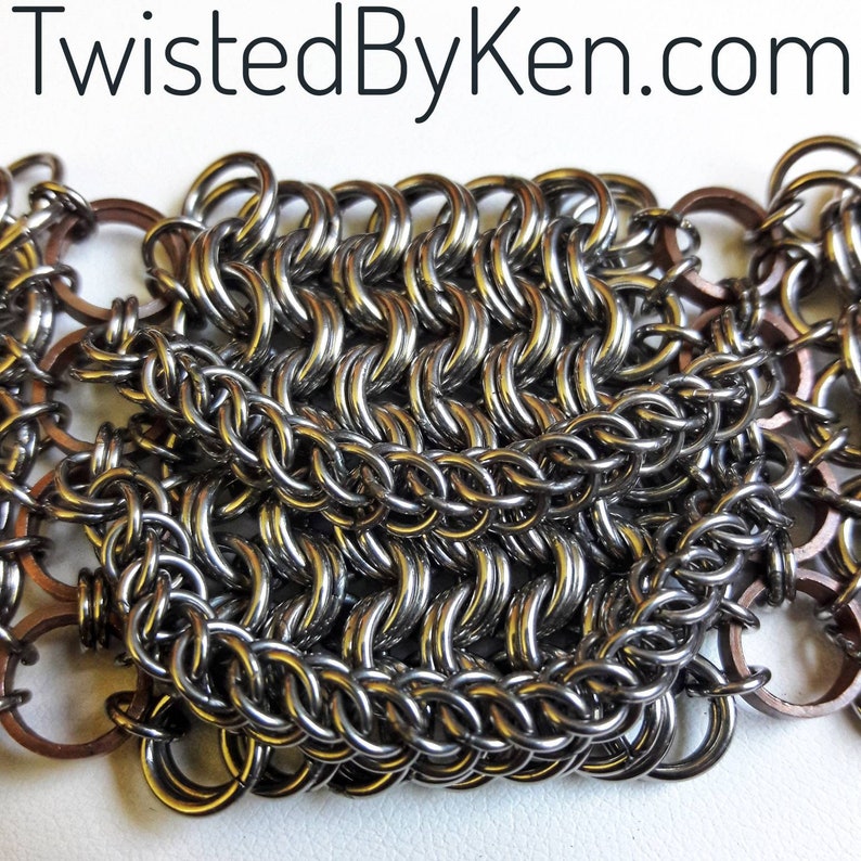 May include: Close-up of a silver chainmail bracelet with copper accents. The chainmail is made of small, interlocking metal rings.