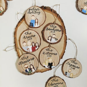 May include: A set of ten personalized wood ornaments with painted portraits and names. The ornaments are decorated with the year 2019 and some include additional text like "The Arneros" and "October 26, 2019".