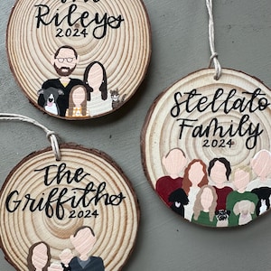 May include: Three personalized wood slice ornaments with painted family portraits and the text "The Rileys 2024", "The Griffiths 2024", and "Stellato Family 2024".