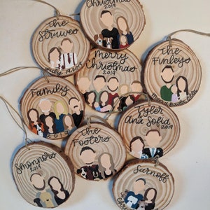 May include: A set of ten round wooden ornaments with painted portraits of families. Each ornament features a different family name and the year 2019. The ornaments are decorated with brown, black, white, and red paint.