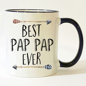 May include: White ceramic coffee mug with a black rim and handle. The mug has black text that reads "Best Pap Pap Ever" with two arrows on either side of the text.