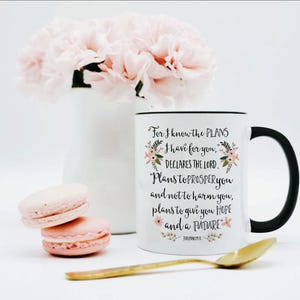 May include: A white ceramic mug with a black handle and rim, featuring the black printed text: For I know the PLANS I have for you, DECLARES THE LORD. Plans to PROSPER you and not to harm you, plans to give you HOPE and a FUTURE. Jeremiah 29:11.