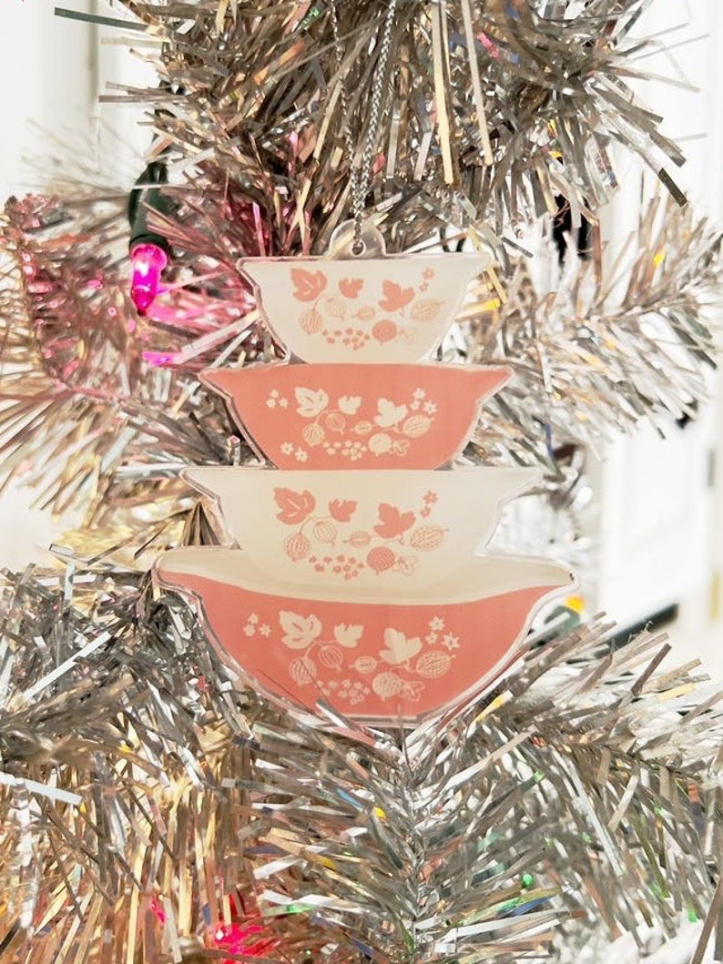 May include: A pink and white Christmas ornament shaped like a stack of three nesting bowls with a floral pattern.