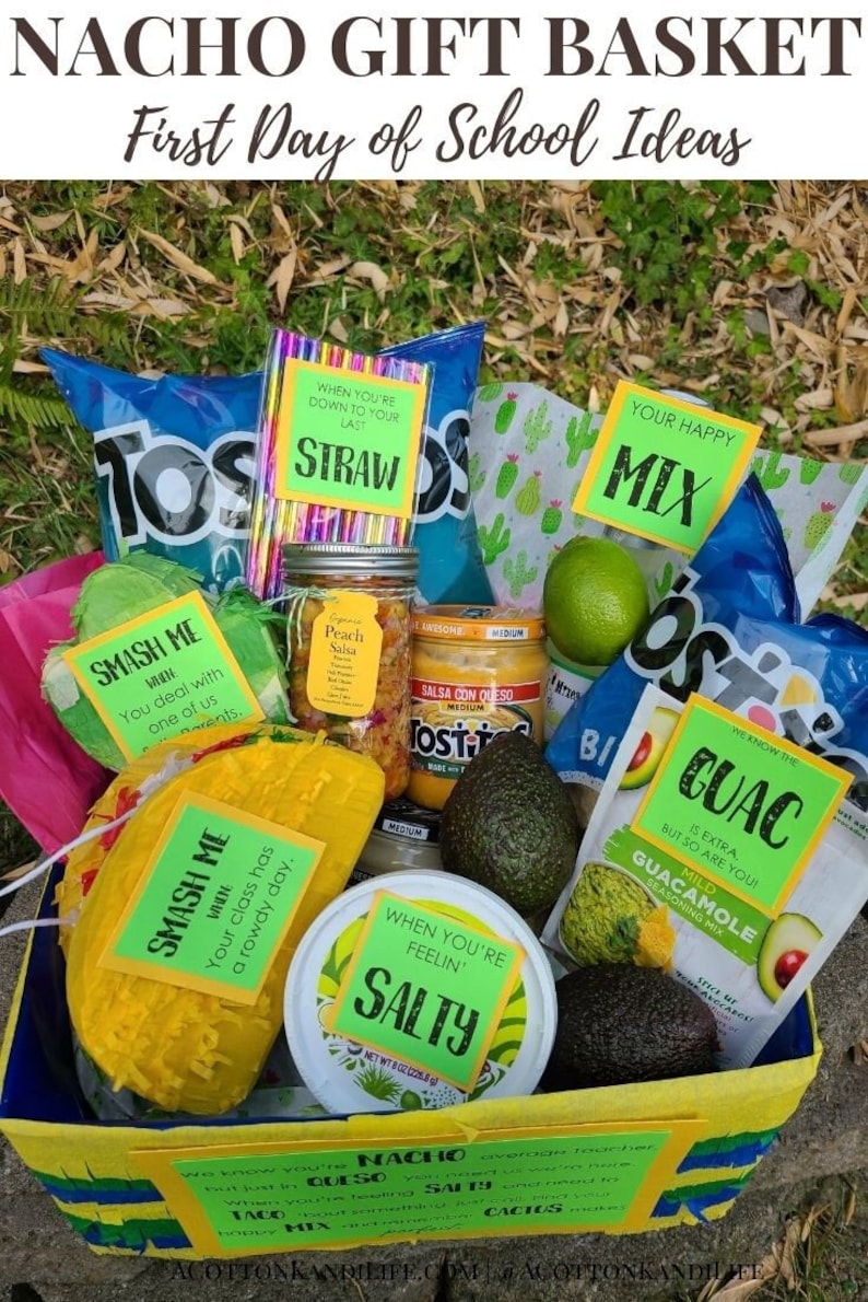 May include: A yellow and blue basket filled with various snacks and ingredients for making nachos. The items include tortilla chips, salsa, guacamole, cheese, limes, and a bag of nacho cheese. The basket is decorated with green and yellow paper and has a sign that says "Nacho Gift Basket First Day of School Ideas".