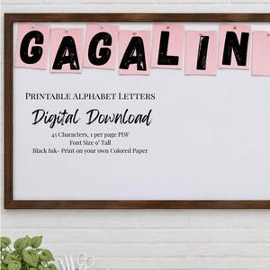 May include: A digital download of printable alphabet letters featuring black ink characters on pink paper pinned to a bulletin board. The text reads: BULLETIN BOARD PRINTABLES FROM Cotton N' Kandi, PRINTABLE ALPHABET LETTERS, Digital Download, 45 Characters, 1 per page PDF, Font Size 22.86 cm Tall, Black Ink- Print on your own Coloured Paper.