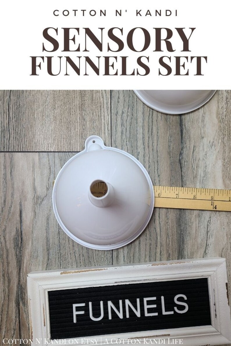 May include: Two white plastic funnels of different sizes, with a wooden ruler measuring 23 cm, and a white wooden sign with black letters that reads "FUNNELS".